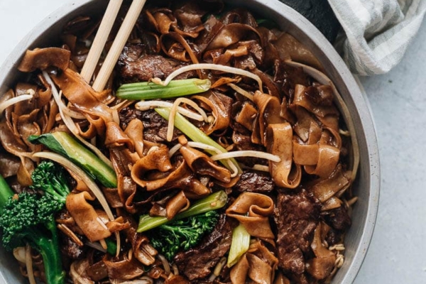 This beef chow fun is loaded with fat noodles, tender steak, and crisp veggies. Even better, now you can cook restaurant-style fried noodles in your home kitchen with a flat skillet! {Gluten-Free Adaptable}