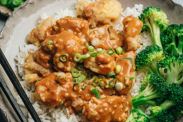 Crispy chicken with peanut butter sauce served with broccoli and rice