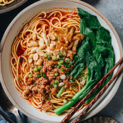 Chongqing noodles is a celebration of spices, using chili oil, numbing Sichuan peppercorns, ginger, garlic and a mixture of sauces to create a bold flavor. Topped with spicy crispy pork, crunchy pickles, and crisp peanuts, it’s the kind of dish that leaves you craving more.